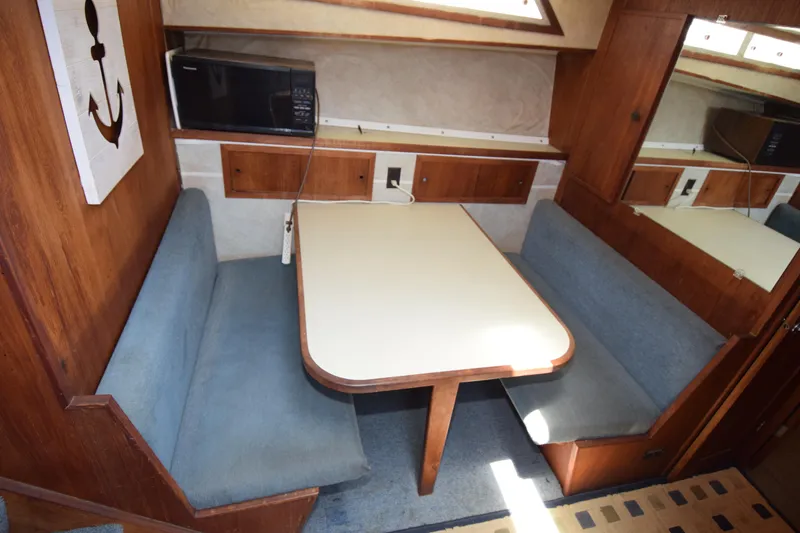 Slide: The Image of 1977 Uniflite 42 Double Cabin interior with dining area, blue seating, and microwave. - 11
