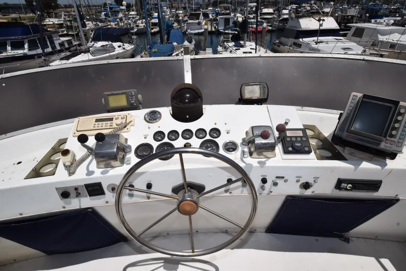 Slide: The Image of 1977 Uniflite 42 Double Cabin helm with navigation instruments and marina view. - 14