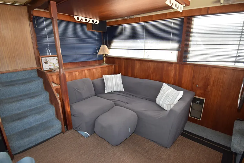 Slide: The Image of 1977 Uniflite 42 Double Cabin interior with cozy seating and wooden paneling. - 2
