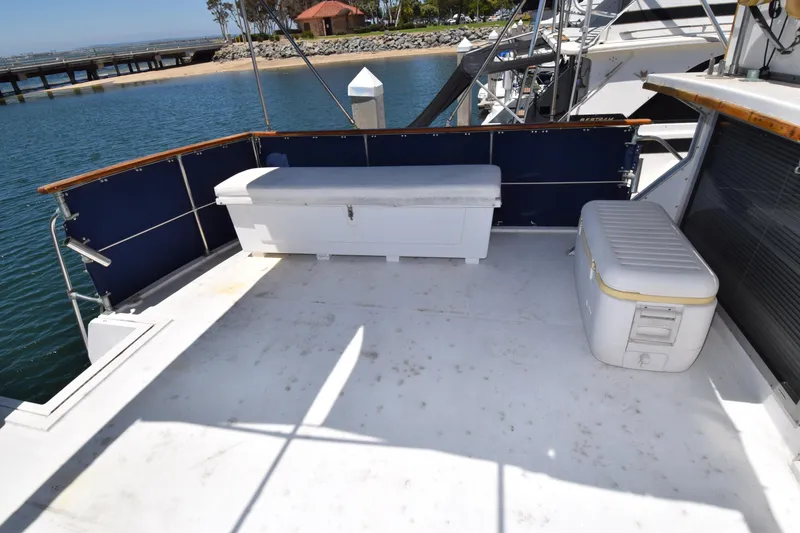Slide: The Image of 1977 Uniflite 42 Double Cabin deck with storage benches, docked by the water. - 20