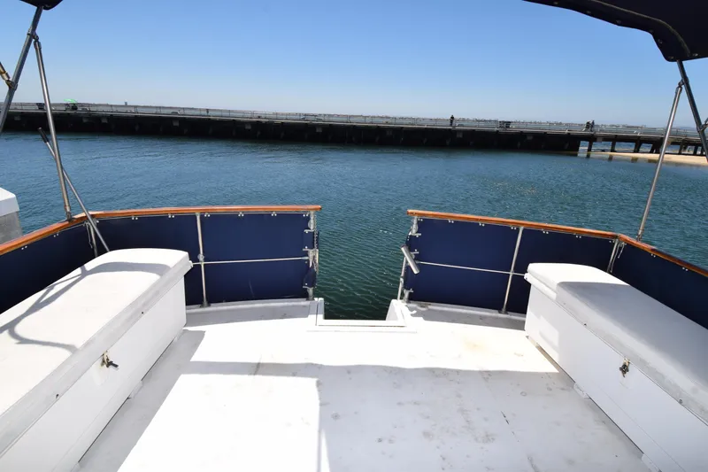 Slide: The Image of 1977 Uniflite 42 Double Cabin yacht deck overlooking calm water and distant bridge. - 23