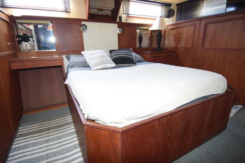 Slide: The Image of 1977 Uniflite 42 Double Cabin bedroom with wooden interior and cozy bedding. - 9