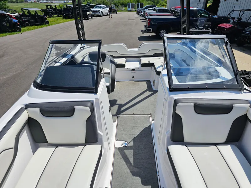 Slide: The Image of 2017 Yamaha Boats SX210 interior with seating and windshield, parked outdoors. - 11