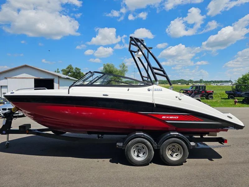 Slide: The Image of 2017 Yamaha SX210 boat on trailer, red and white, under blue sky. - 3