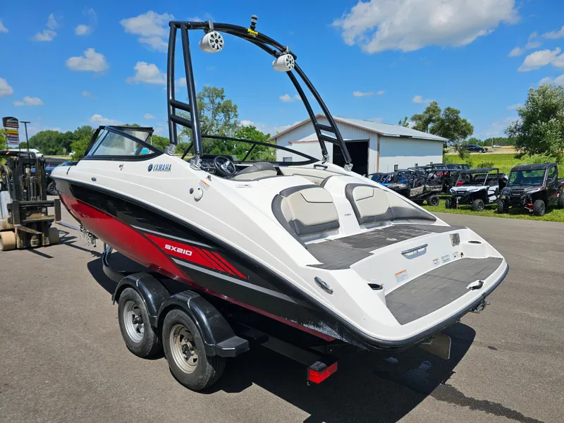 Slide: The Image of 2017 Yamaha SX210 boat on trailer, parked outdoors under a clear blue sky. - 4