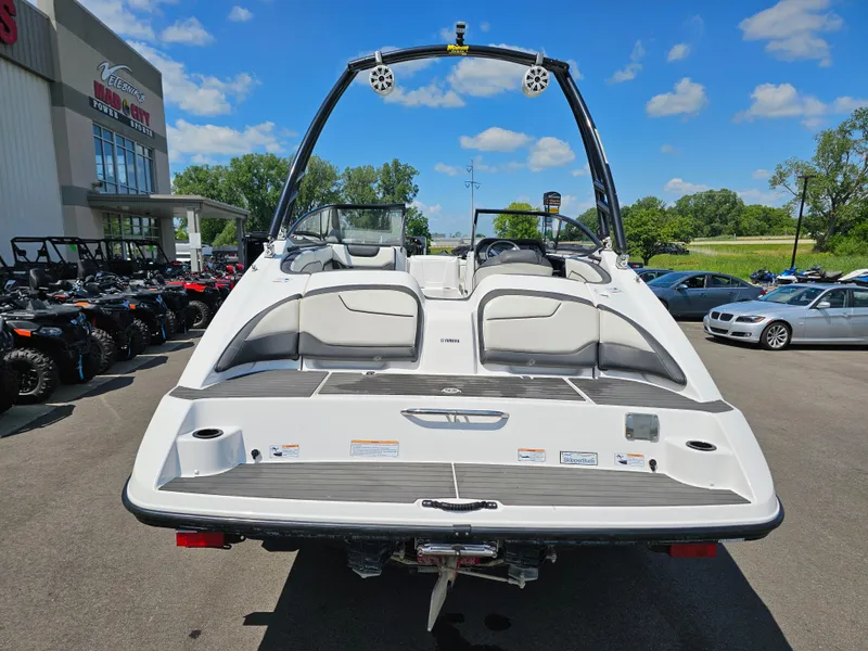 Slide: The Image of 2017 Yamaha Boats SX210 in a dealership lot, showcasing rear view and seating. - 5