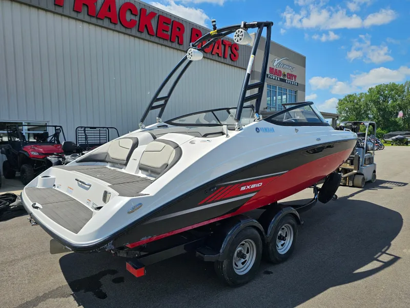 Slide: The Image of 2017 Yamaha Boats SX210 on trailer outside dealership under blue sky. - 6