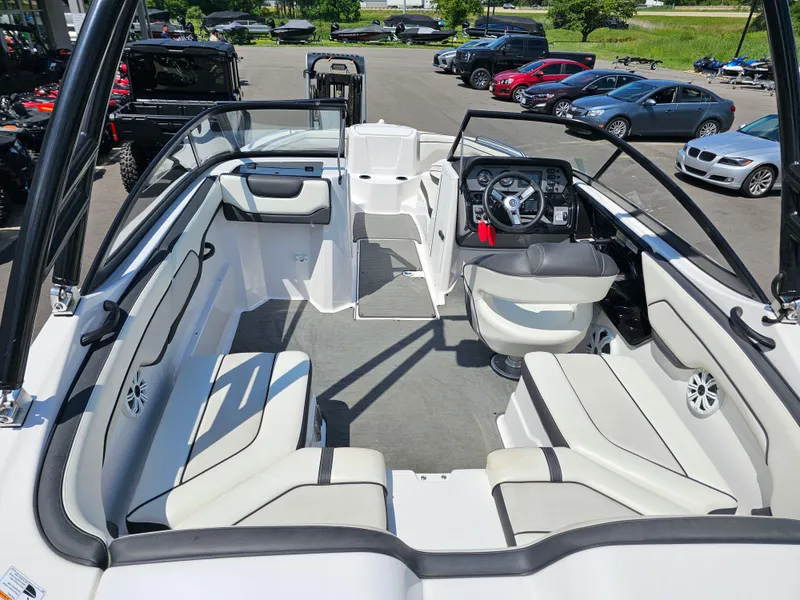 Slide: The Image of 2017 Yamaha Boats SX210 interior with seating and steering wheel, parked outdoors. - 7