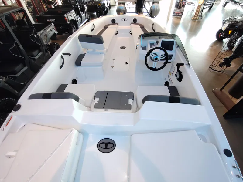 Slide: The Image of 2026 Tahoe T18 boat interior with seating and steering wheel in showroom. - 2