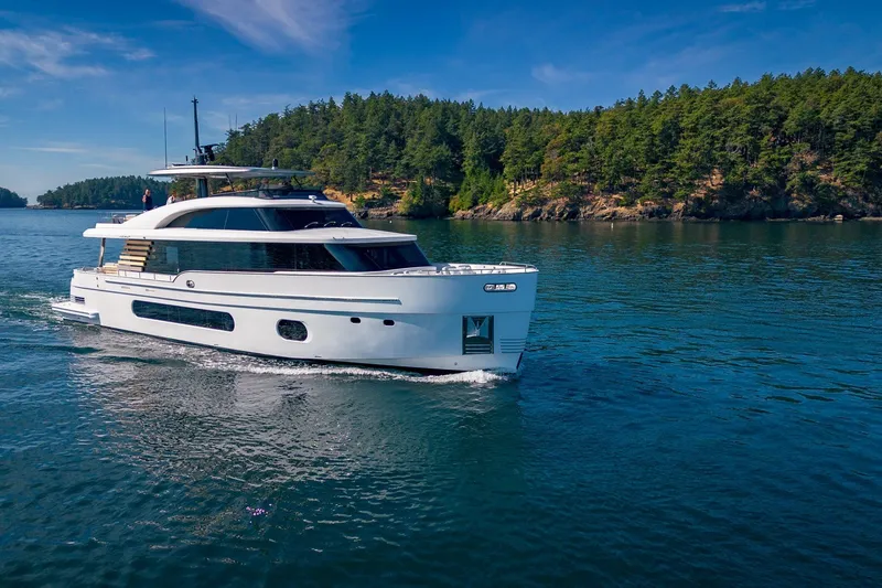 Slide: The Image of 2026 Azimut Magellano 25M yacht cruising on serene waters near a forested shoreline. - 101