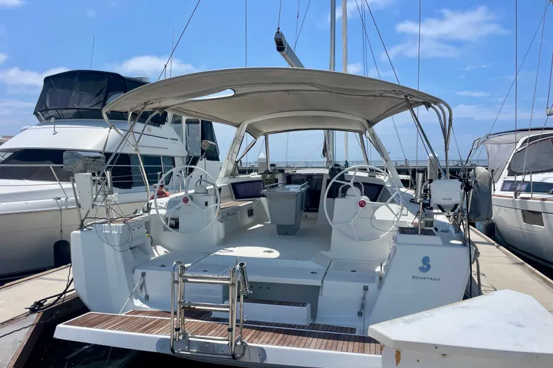 Slide: The Image of 2018 Beneteau Oceanis 48 yacht docked, featuring dual steering wheels and spacious cockpit. - 0