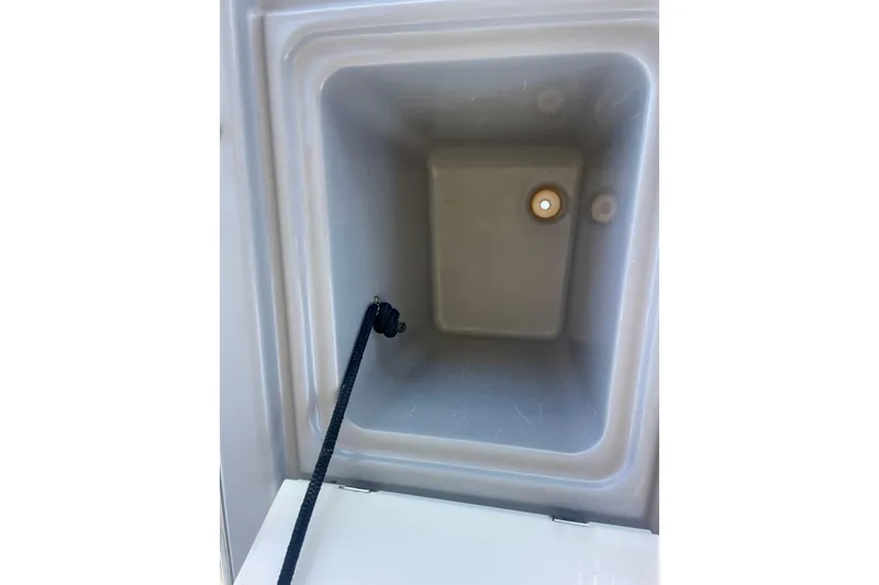 Slide: The Image of Storage compartment inside 2018 Beneteau Oceanis 48 yacht, featuring a drain and rope. - 12