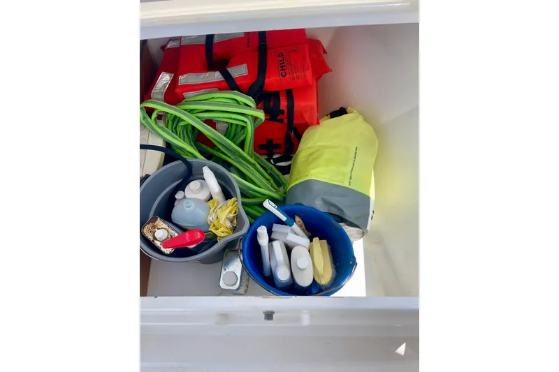 Slide: The Image of Storage compartment on 2018 Beneteau Oceanis 48 with life jackets, ropes, and cleaning supplies. - 24