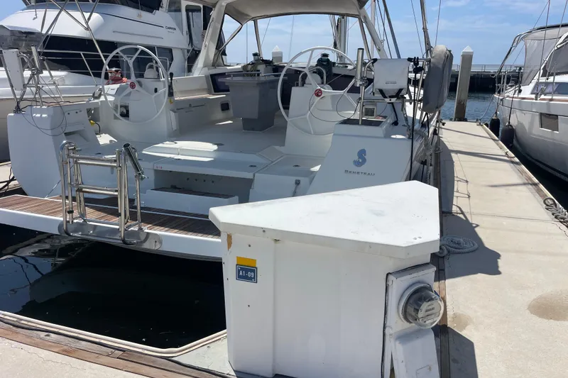 Slide: The Image of 2018 Beneteau Oceanis 48 yacht docked at marina, featuring dual steering wheels. - 33
