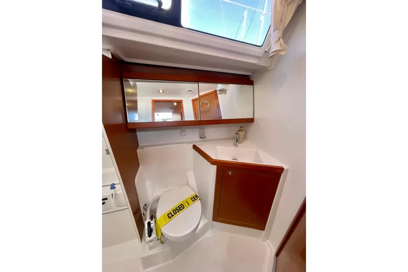 Slide: The Image of Beneteau Oceanis 48 yacht bathroom with mirror, sink, and closed toilet, 2018 model. - 50
