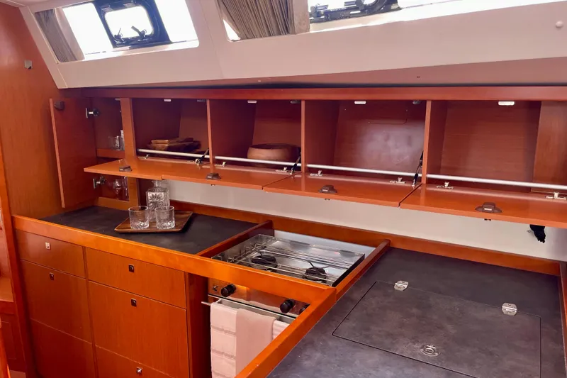 Slide: The Image of Interior of 2018 Beneteau Oceanis 48 yacht kitchen with wooden cabinets and modern appliances. - 59