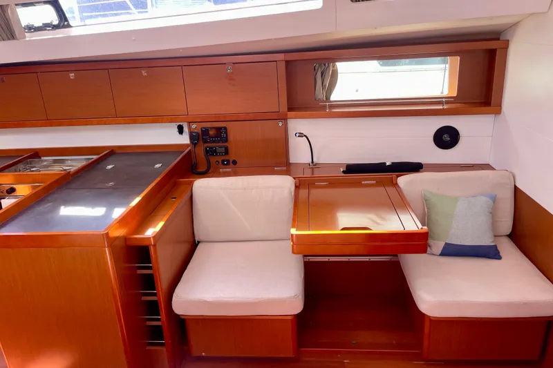 Slide: The Image of Interior of 2018 Beneteau Oceanis 48 yacht with wooden cabinetry and seating area. - 64