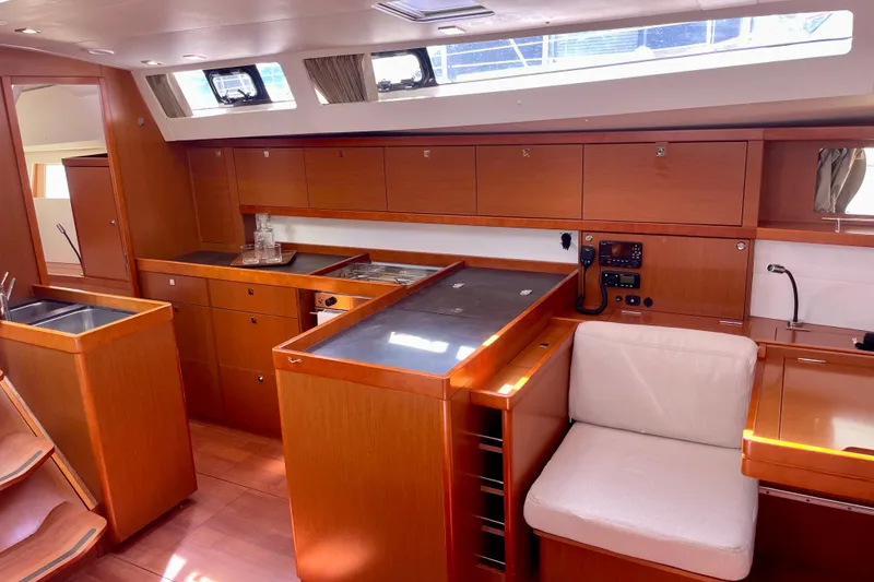 Slide: The Image of Interior of 2018 Beneteau Oceanis 48 yacht, featuring a modern kitchen and seating area. - 65