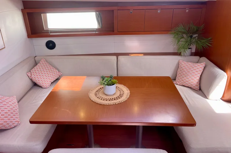Slide: The Image of Interior of 2018 Beneteau Oceanis 48 yacht with cozy seating and wooden table. - 68