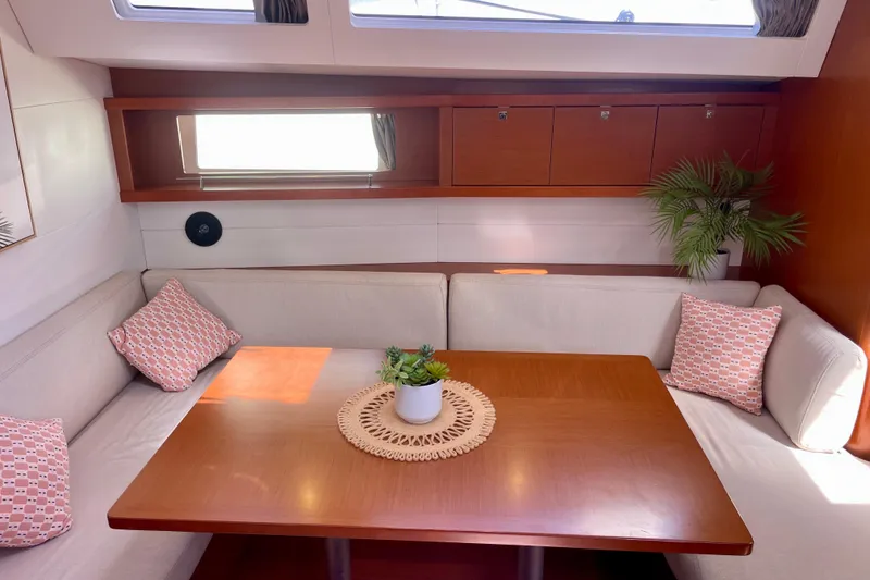 Slide: The Image of Interior of 2018 Beneteau Oceanis 48 yacht with cozy seating and wooden table. - 69