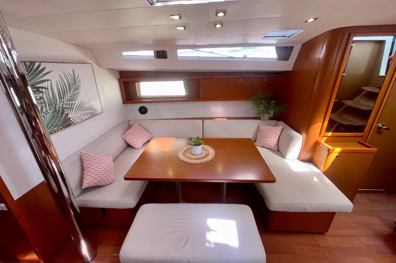 Slide: The Image of 2018 Beneteau Oceanis 48 interior with cozy seating, wooden table, and decorative accents. - 71