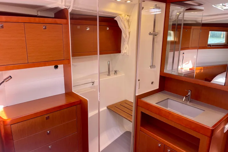 Slide: The Image of Luxurious 2018 Beneteau Oceanis 48 yacht interior with modern bathroom and wooden cabinetry. - 75