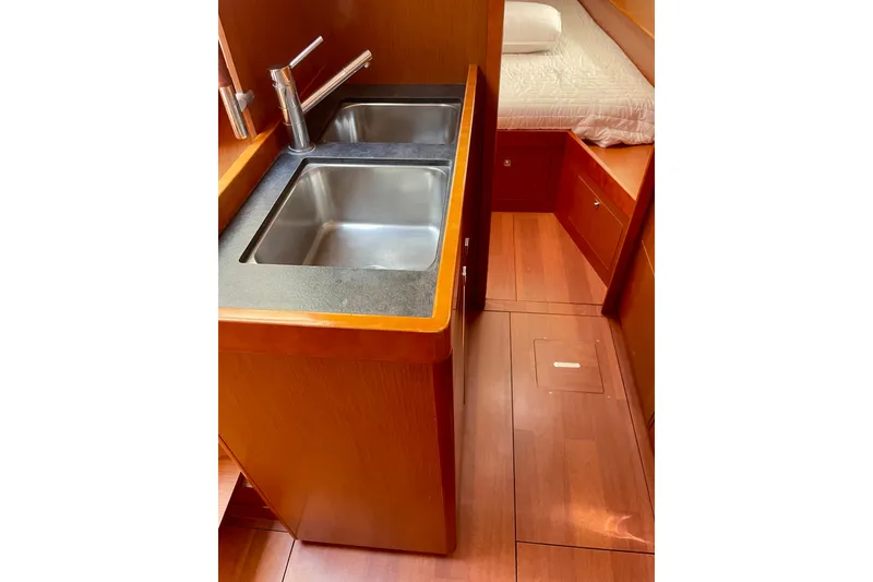 Slide: The Image of 2018 Beneteau Oceanis 48 interior with dual sinks and wooden cabinetry. - 81