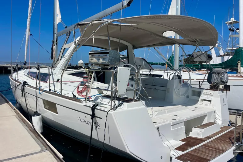 Slide: The Image of 2018 Beneteau Oceanis 48 yacht docked at marina, featuring spacious deck and modern design. - 84