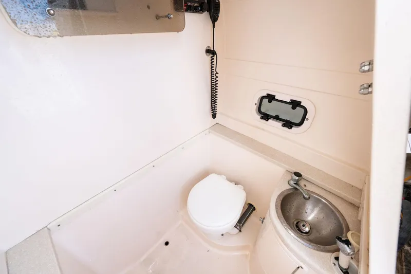 Slide: The Image of 2009 Intrepid 323 CC boat interior with toilet and sink. - 16