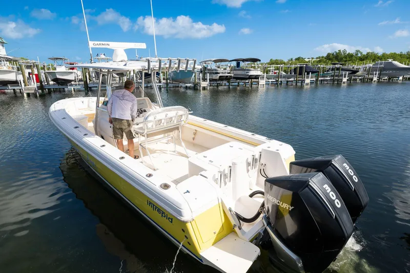 Slide: The Image of 2009 Intrepid 323 CC boat with dual Mercury engines in a marina setting. - 20