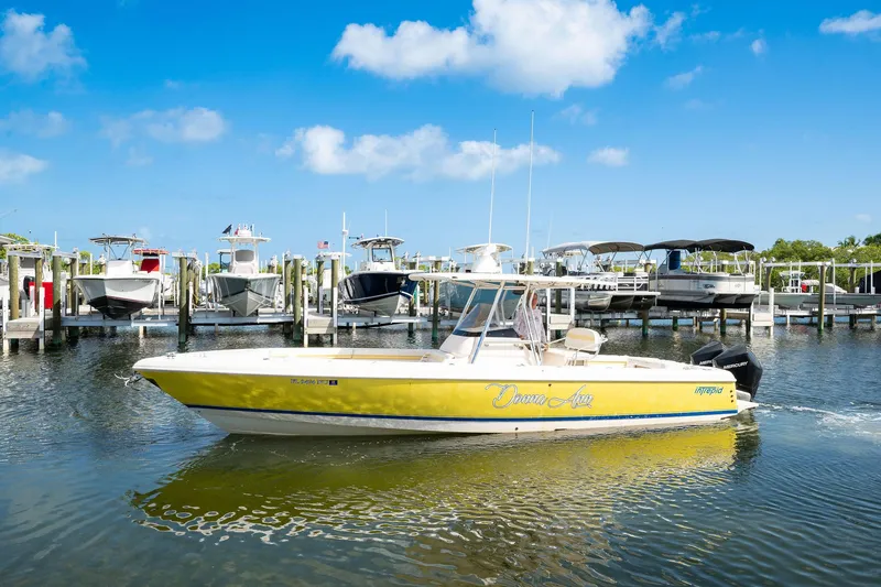 Slide: The Image of Yellow 2009 Intrepid 323 CC boat docked in a marina under a clear blue sky. - 22