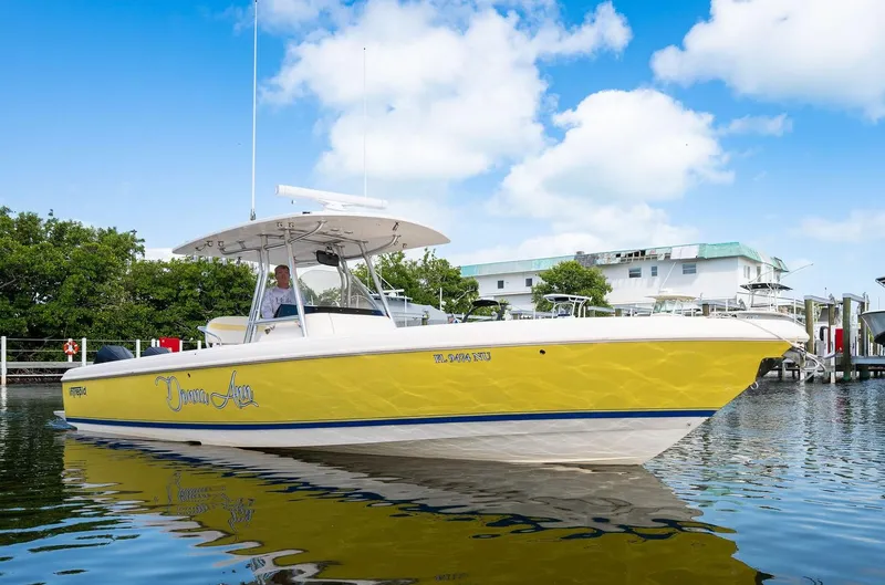 Slide: The Image of 2009 Intrepid 323 CC boat with yellow hull on calm water, under blue sky. - 28