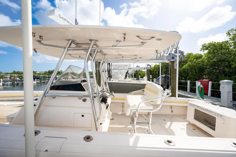 Slide: The Image of 2009 Intrepid 323 CC boat interior with helm, seating, and clear sky background. - 3