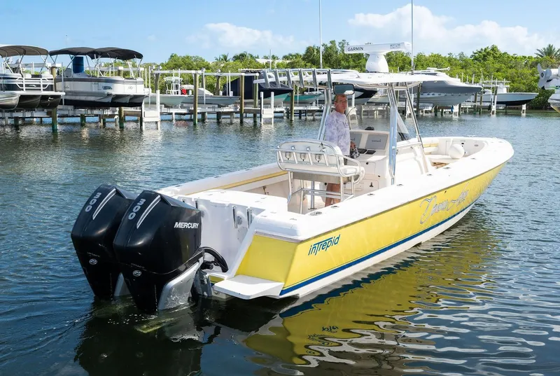 Slide: The Image of 2009 Intrepid 323 CC boat with dual Mercury engines docked in marina. - 30