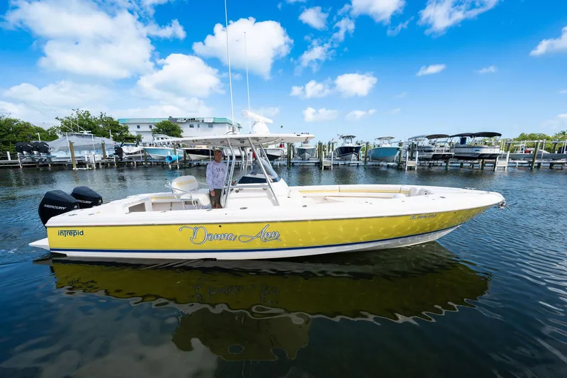 Slide: The Image of 2009 Intrepid 323 CC boat in marina, yellow hull, clear sky, calm water. - 32