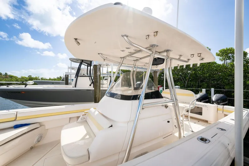 Slide: The Image of 2009 Intrepid 323 CC boat with T-top and dual Mercury engines docked under blue sky. - 6