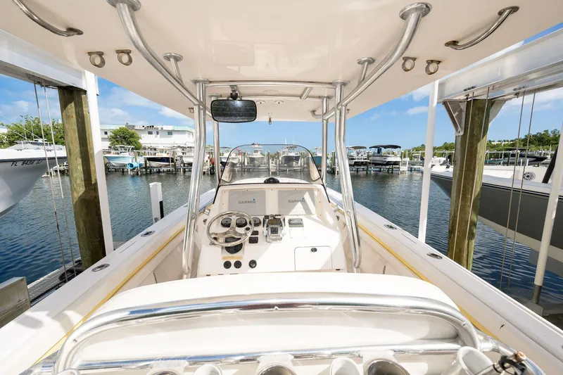 Slide: The Image of 2009 Intrepid 323 CC boat interior at marina, featuring steering console and equipment. - 7