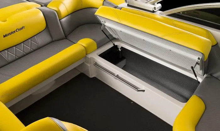 Slide: The Image of Manufacturer Provided Image: 2015 MasterCraft X10 boat interior with yellow and gray seating and open storage compartment. - 16