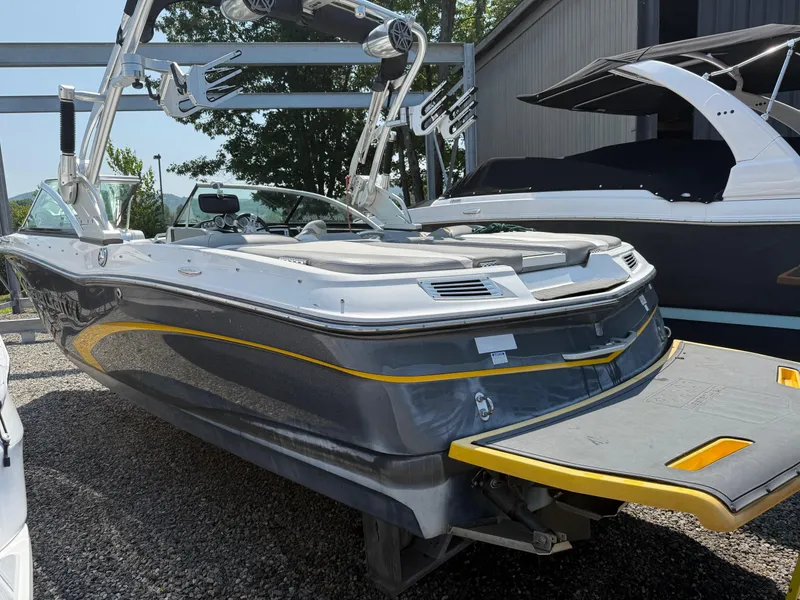 Slide: The Image of 2015 MasterCraft X10 boat with sleek design and yellow accents, parked outdoors. - 5