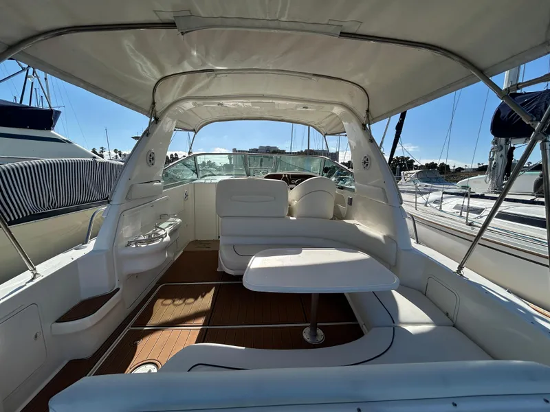 Slide: The Image of 2001 Sea Ray 310 Sundancer interior with seating and table, docked at marina. - 1