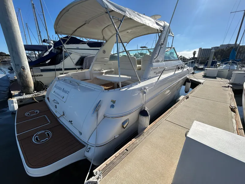 Slide: The Image of 2001 Sea Ray 310 Sundancer docked at marina under clear blue sky. - 10