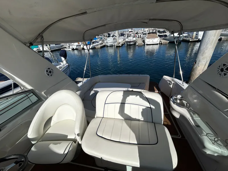 Slide: The Image of 2001 Sea Ray 310 Sundancer boat interior with seating and table, docked at marina. - 3