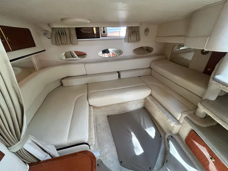 Slide: The Image of Interior of 2001 Sea Ray 310 Sundancer, featuring beige seating and carpeted flooring. - 8