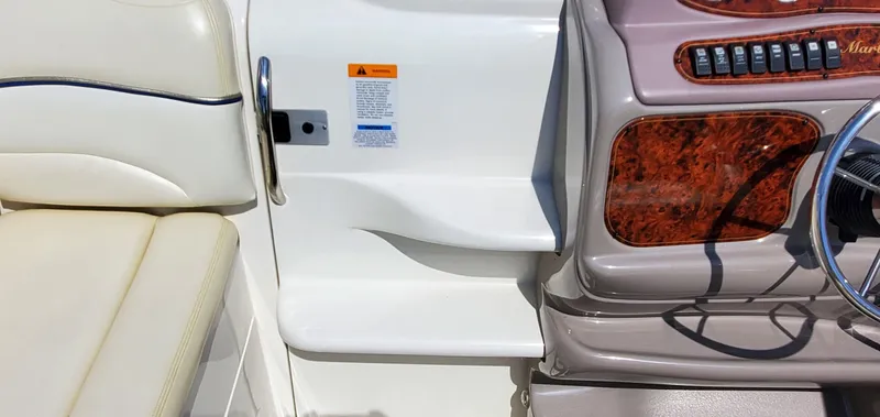 Slide: The Image of 2003 Wellcraft 2400 Martinique boat interior with beige seating and wood-accented dashboard. - 12