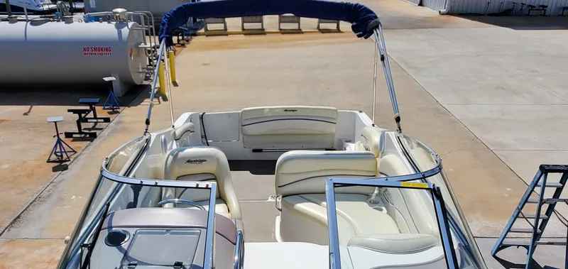 Slide: The Image of 2003 Wellcraft 2400 Martinique boat with white seating and blue canopy in a marina. - 15