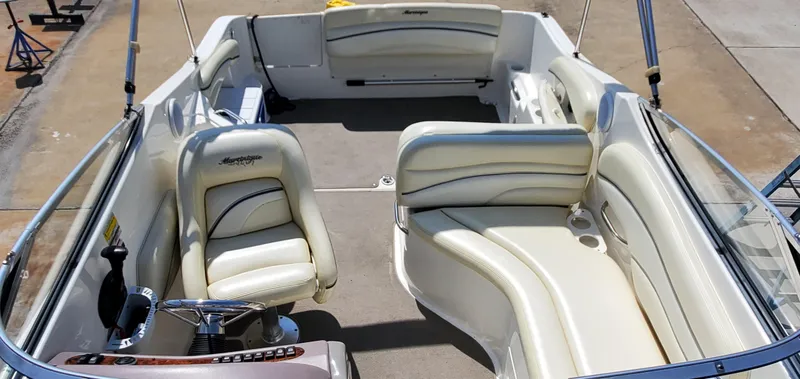 Slide: The Image of 2003 Wellcraft 2400 Martinique boat interior with cream leather seating and steering wheel. - 16