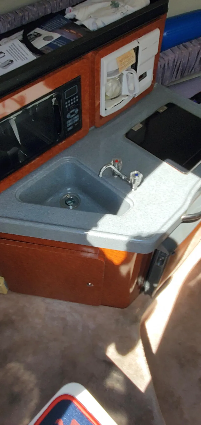 Slide: The Image of 2003 Wellcraft 2400 Martinique boat interior with kitchenette, sink, and microwave. - 18