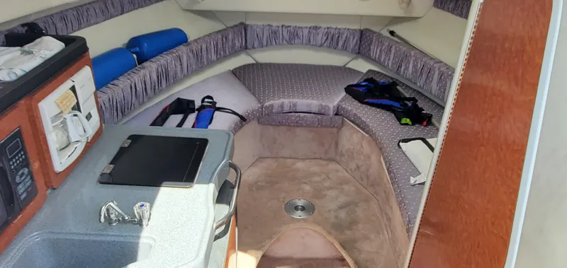 Slide: The Image of Interior of a 2003 Wellcraft 2400 Martinique boat with kitchenette and seating area. - 19