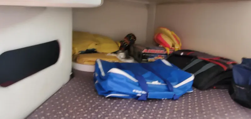 Slide: The Image of Interior storage area of a 2003 Wellcraft 2400 Martinique boat with various items. - 21