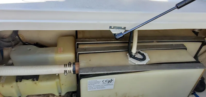 Slide: The Image of 2003 Wellcraft 2400 Martinique engine compartment with visible components and hoses. - 26
